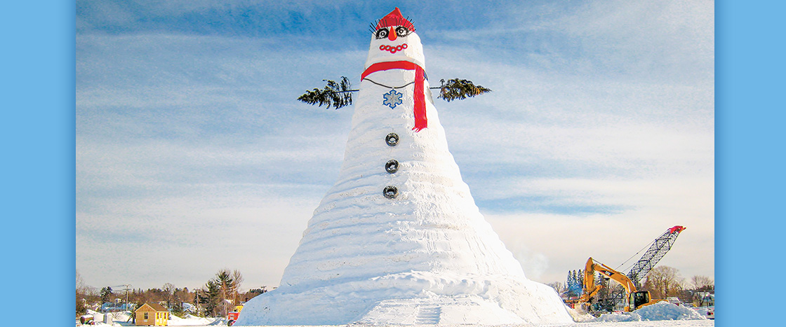 Image of world's tallest snowperson with wreath eyes and red tire mouths